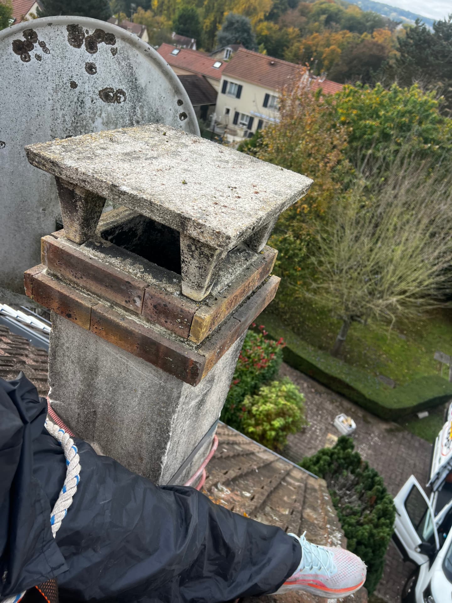Souche de cheminée couverte de mousses et lichens lors d'une intervention en toiture