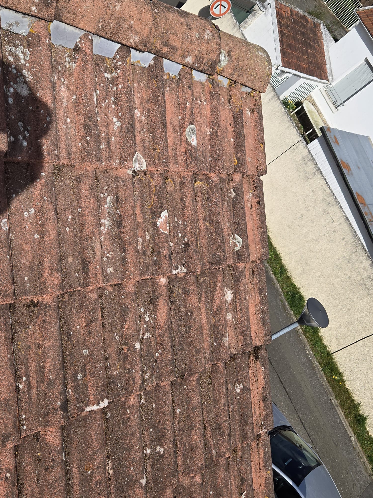 Pan de toiture en tuiles nettoyé et traité après une intervention de démoussage dans le Val-d'Oise